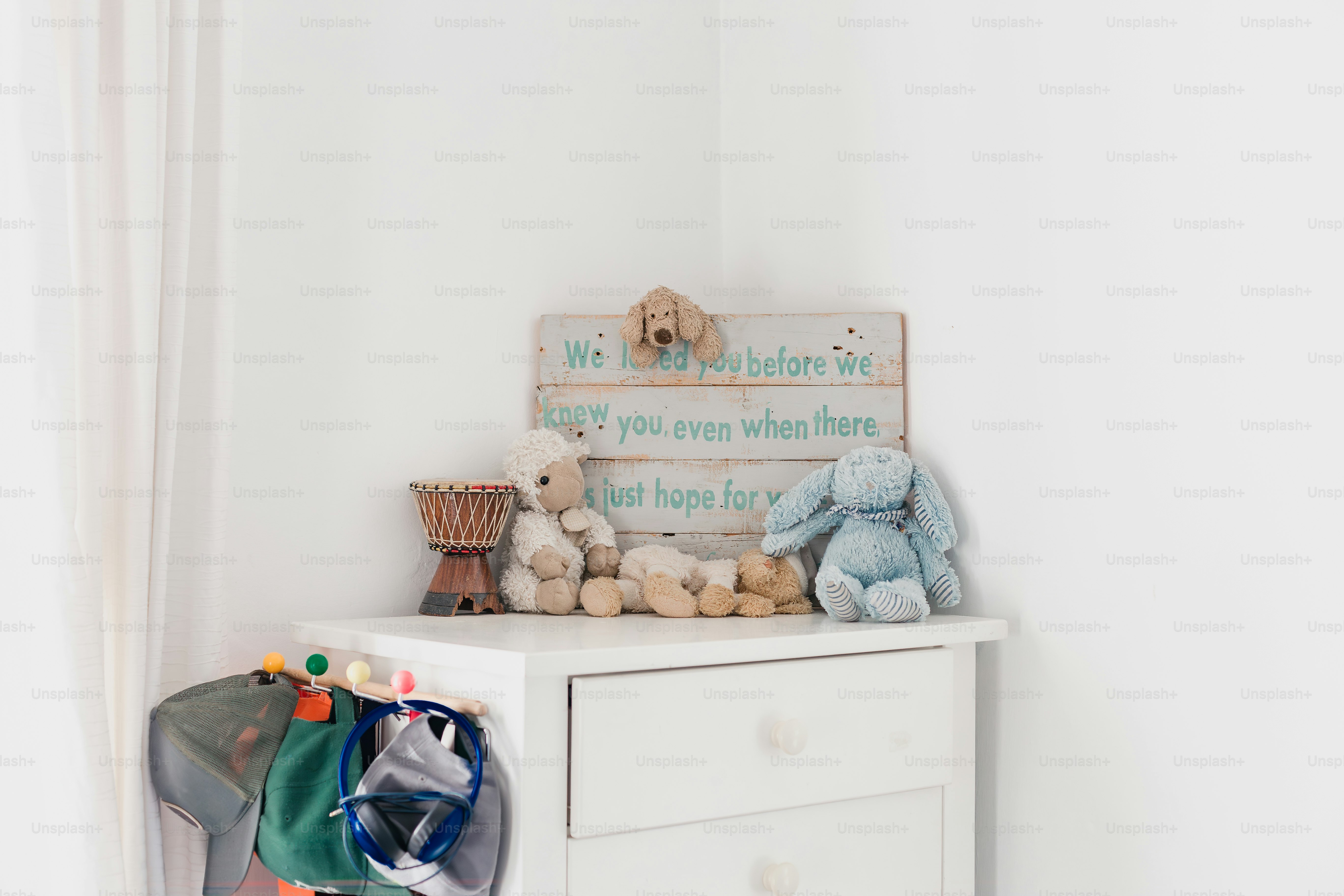 a white chest of drawers with stuffed animals on top of it