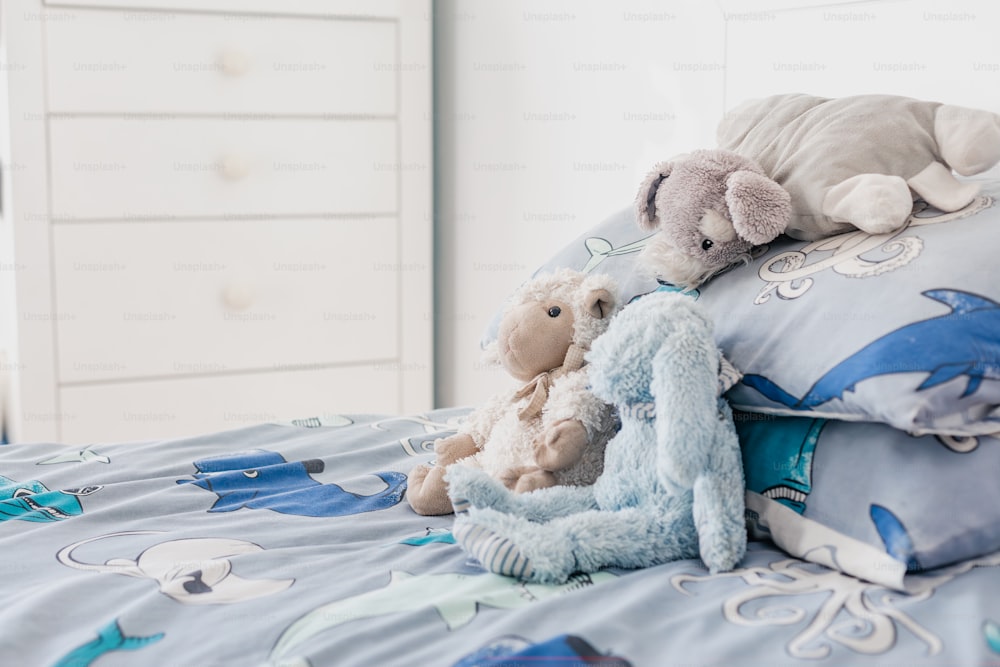 two stuffed animals sitting on top of a bed