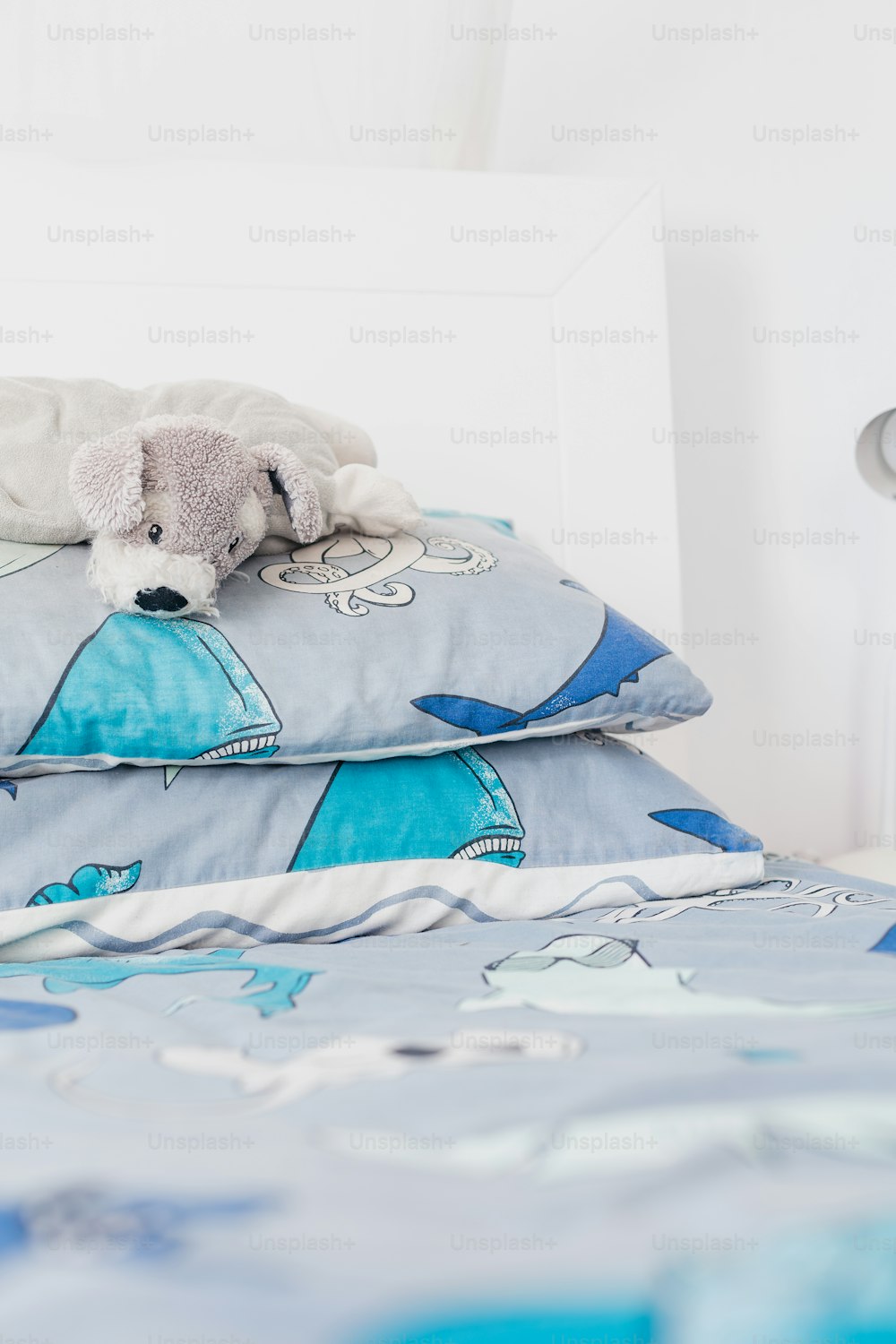 a stuffed animal laying on a pillow on a bed