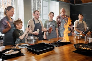 um grupo de pessoas em pé ao redor de uma mesa de madeira