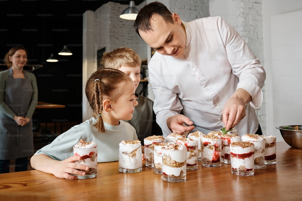 a man and a little girl standing in front of a table filled with desserts