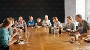 un gruppo di persone sedute attorno a un tavolo di legno