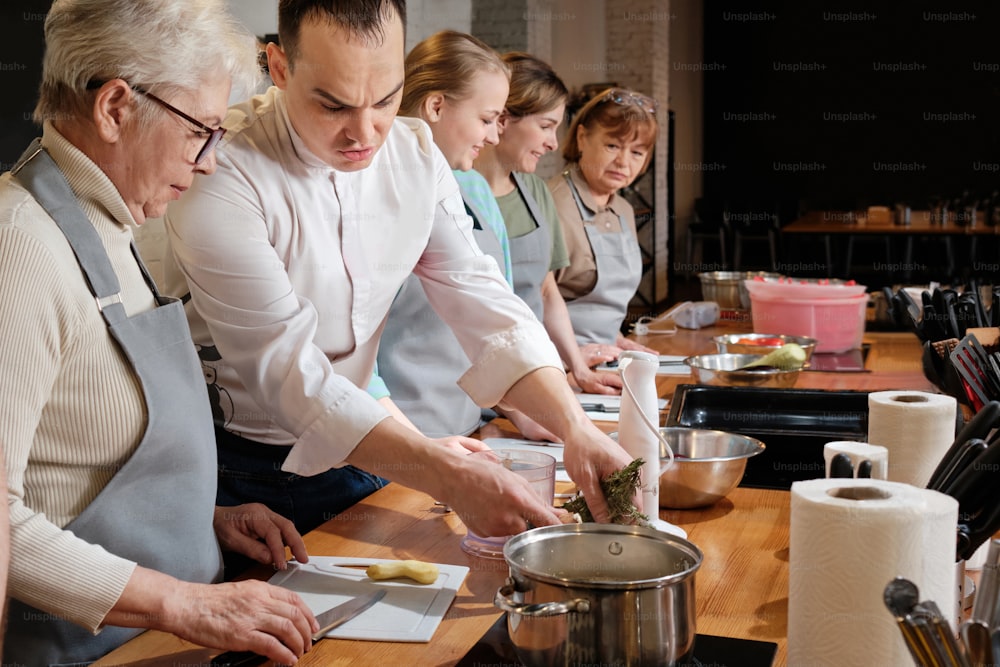 a group of people standing around a table preparing food