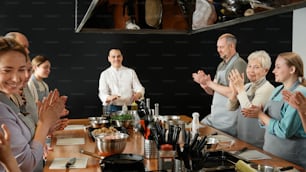 a group of people standing around a table clapping