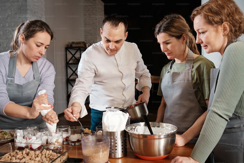 a group of people standing around a table preparing food