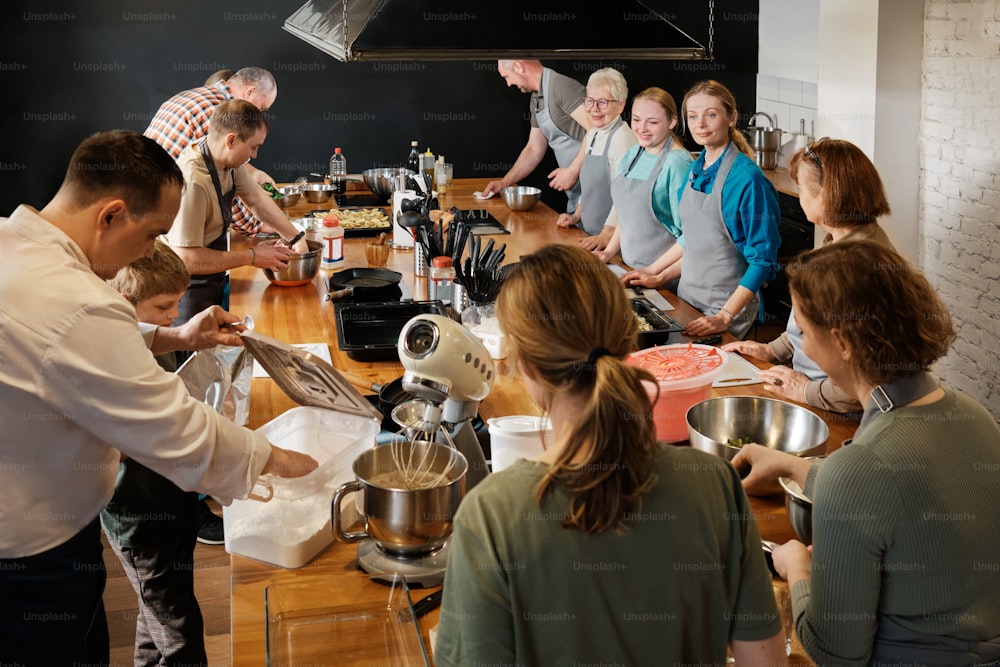 un gruppo di persone in piedi intorno a un bancone della cucina