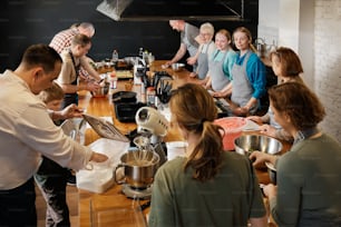 a group of people standing around a kitchen counter
