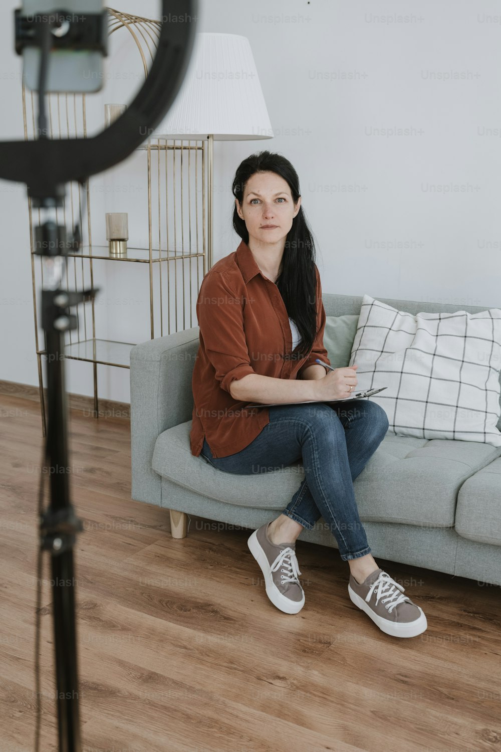 a woman sitting on a couch in front of a camera