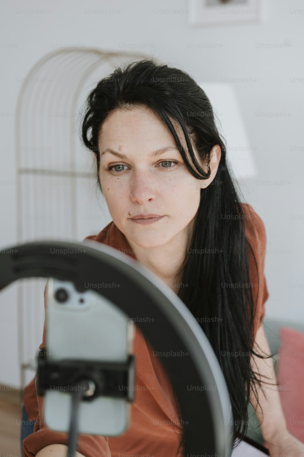 a woman with long black hair holding a camera