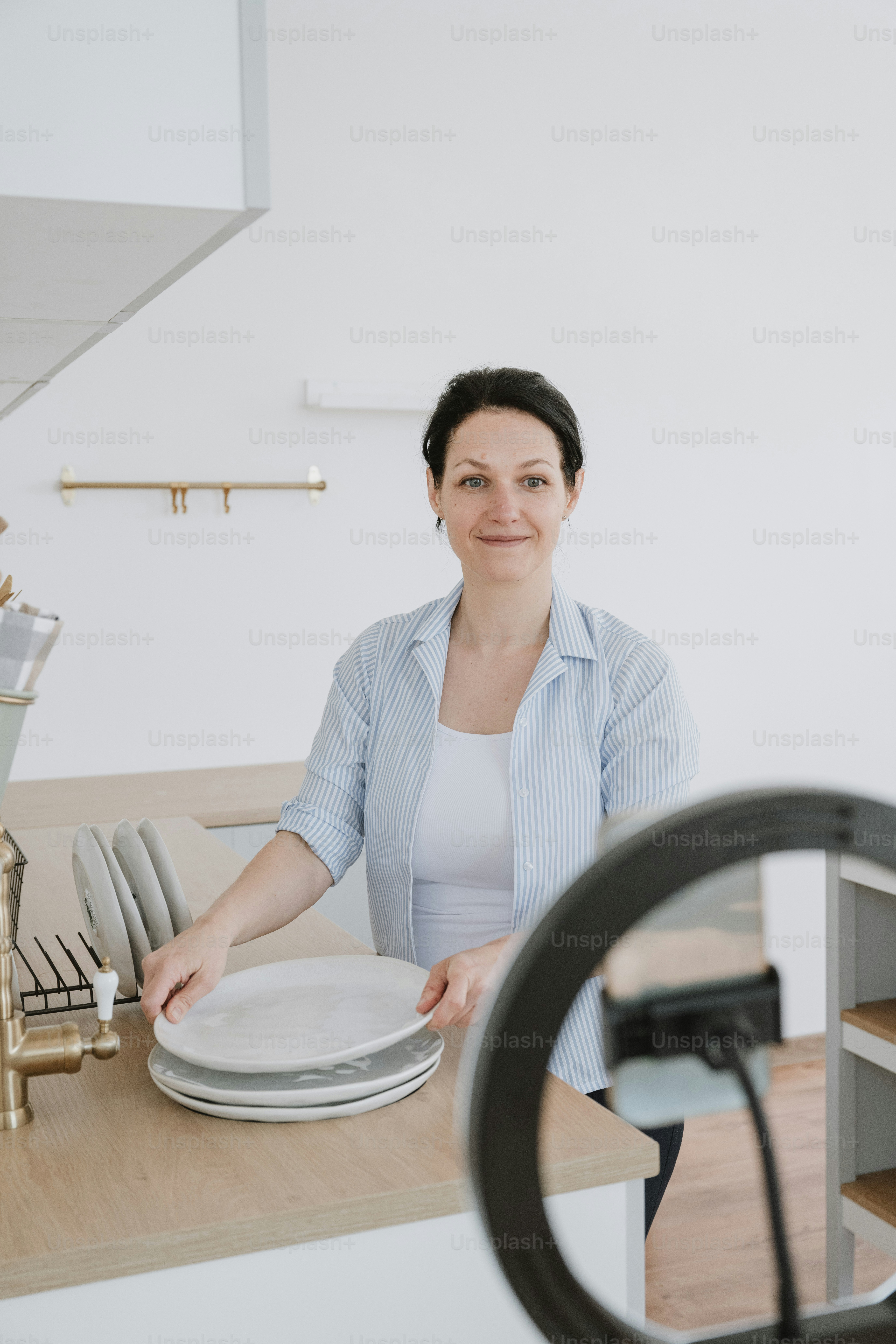 A woman standing behind a counter with plates on it photo – Woman Image ...