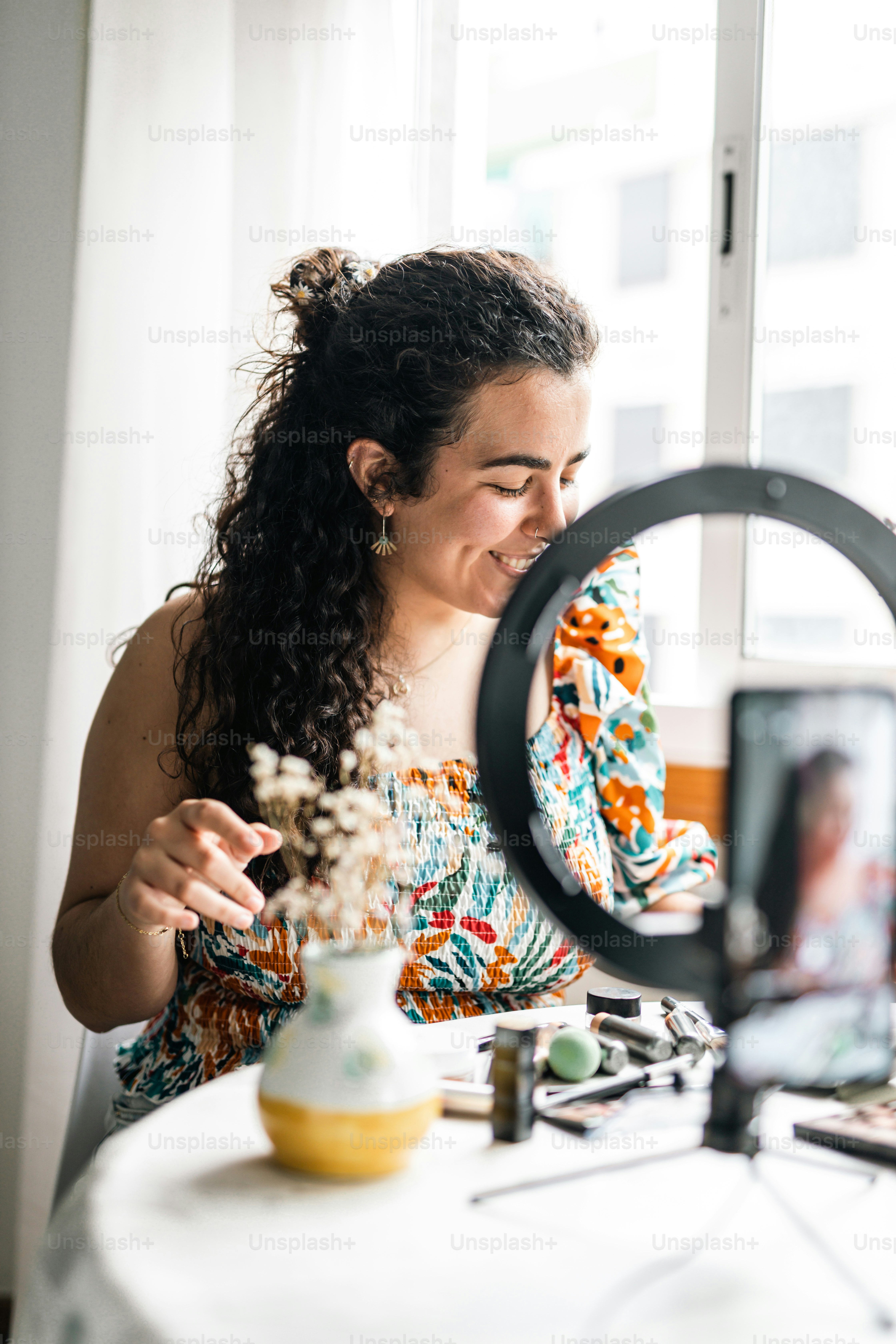 a woman sitting at a table looking at a camera