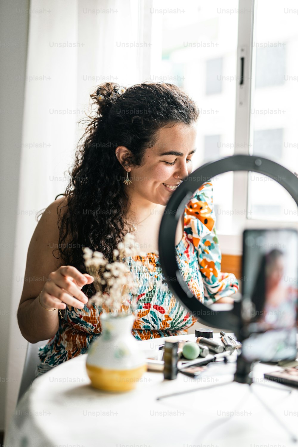 a woman sitting at a table looking at a camera