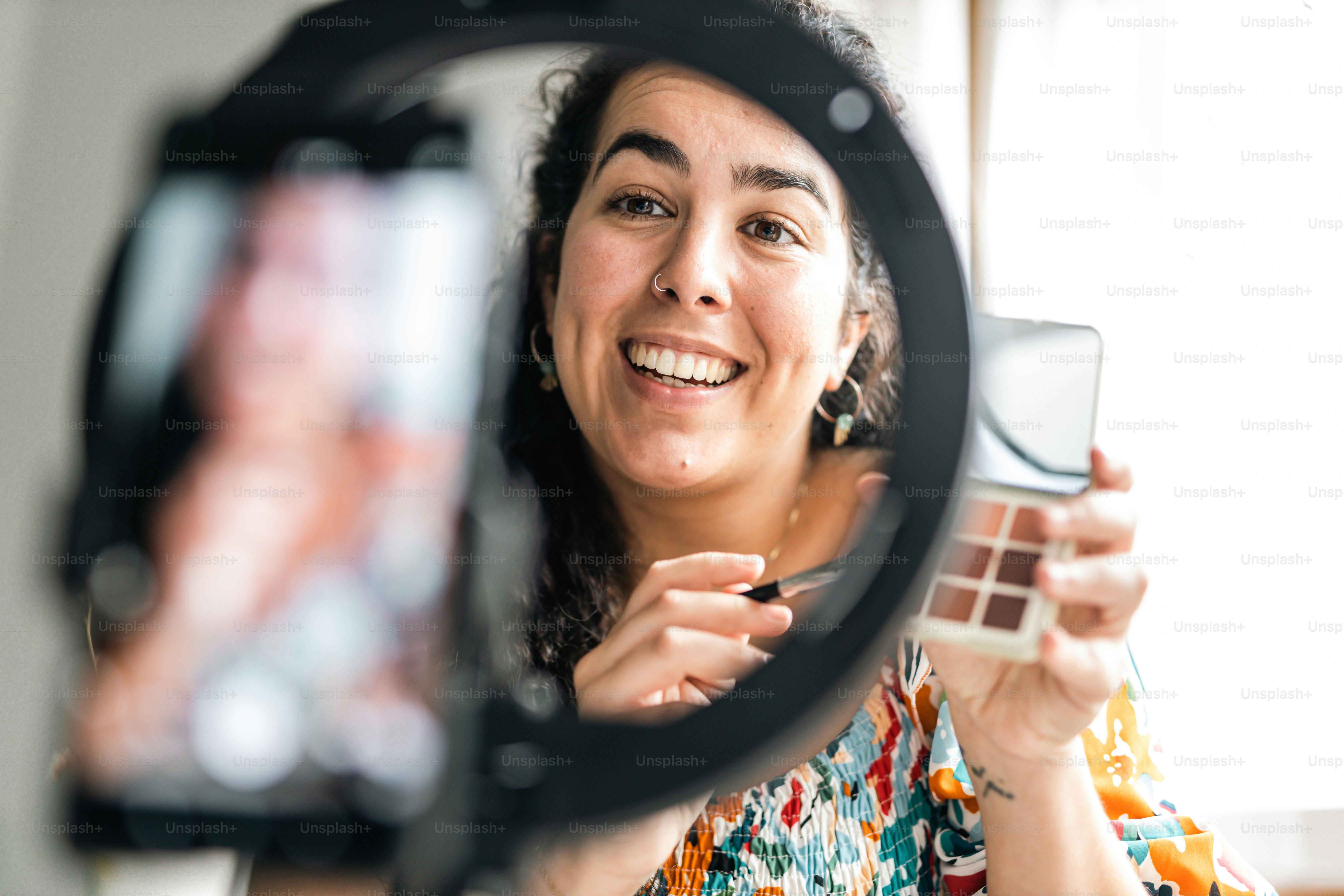 a woman is holding a camera and smiling