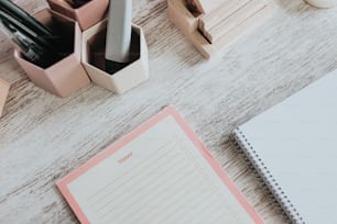 a desk with a notepad, pen, pencil holder, and other office supplies