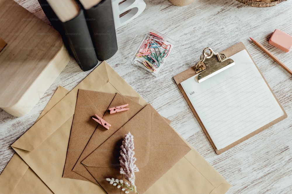 uma mesa com bloco de notas, caneta, lápis e um clipe de papel