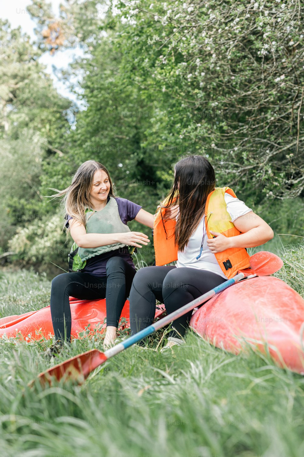 two women sitting on a raft in the grass