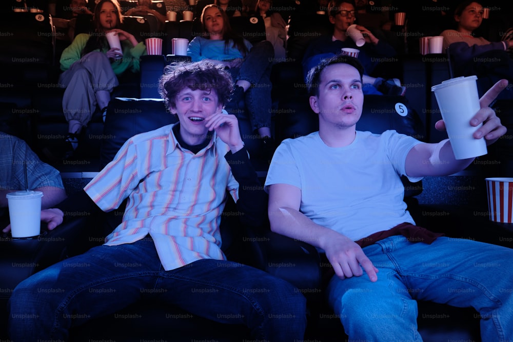 two young men sitting in a movie theater