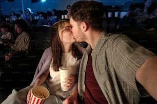 a man and a woman kissing while watching a movie