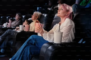 Una mujer con cabello rosado viendo una película