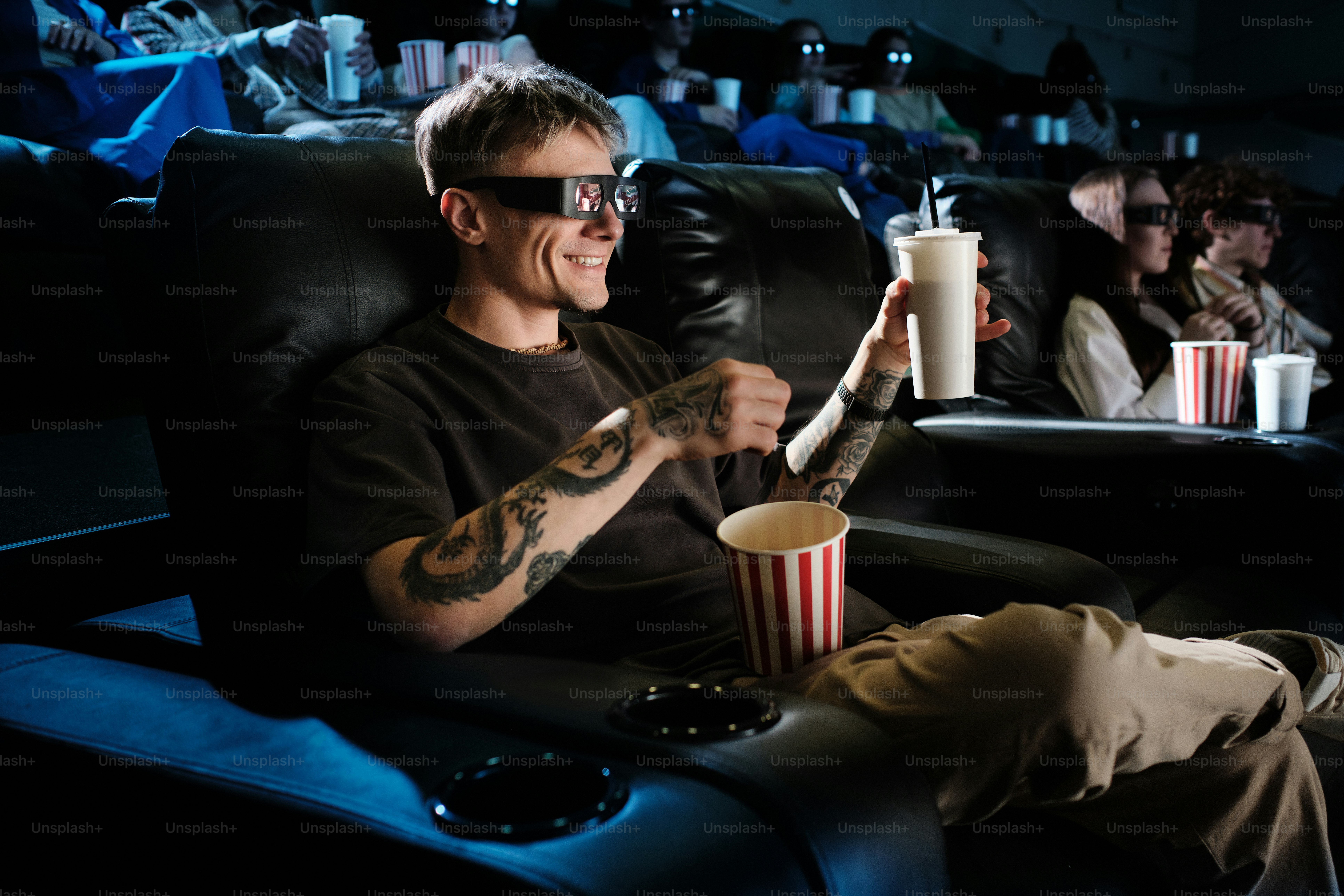 a man sitting in a chair holding a drink