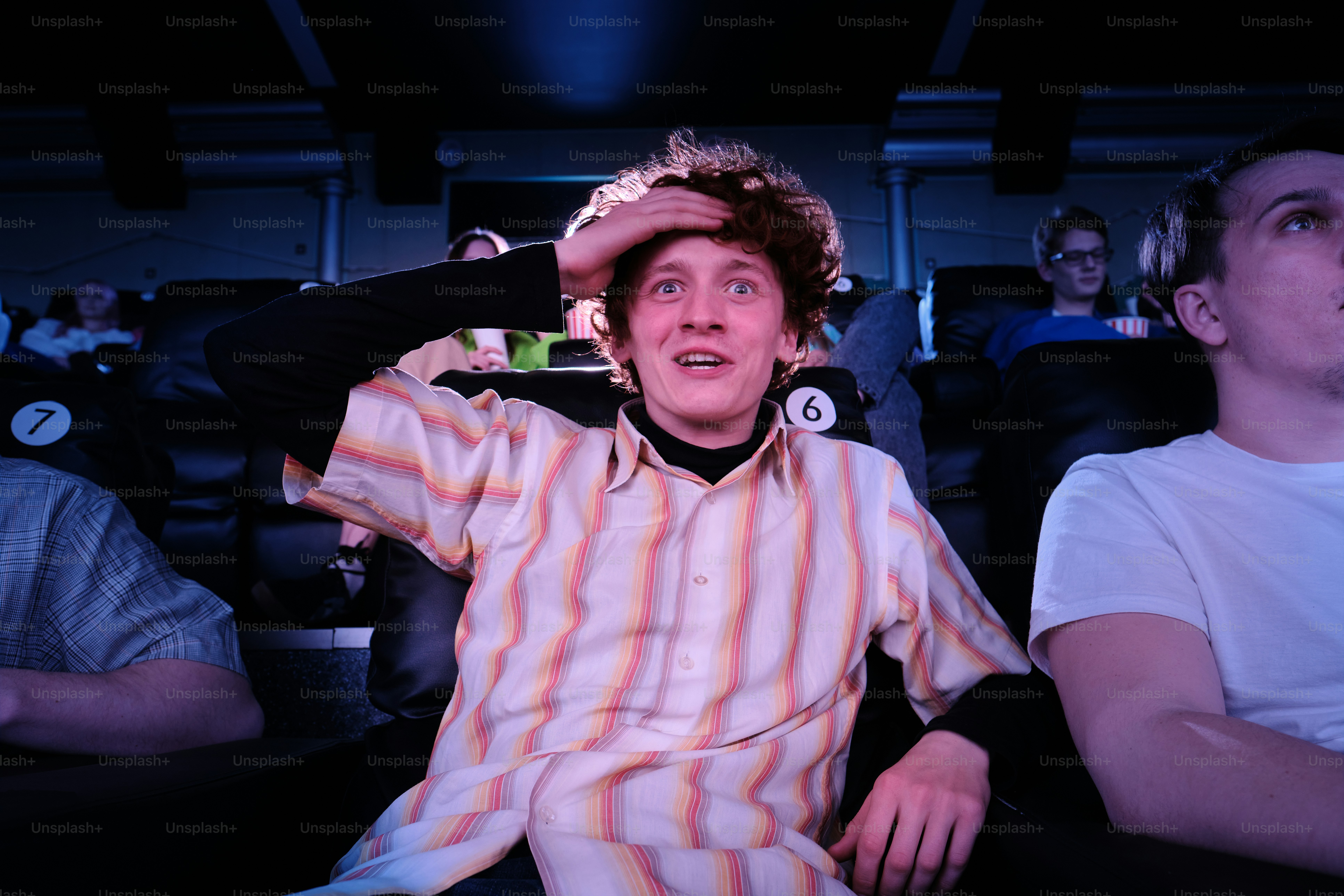 머리에 손을 얹고 의자에 앉아 있는 남자