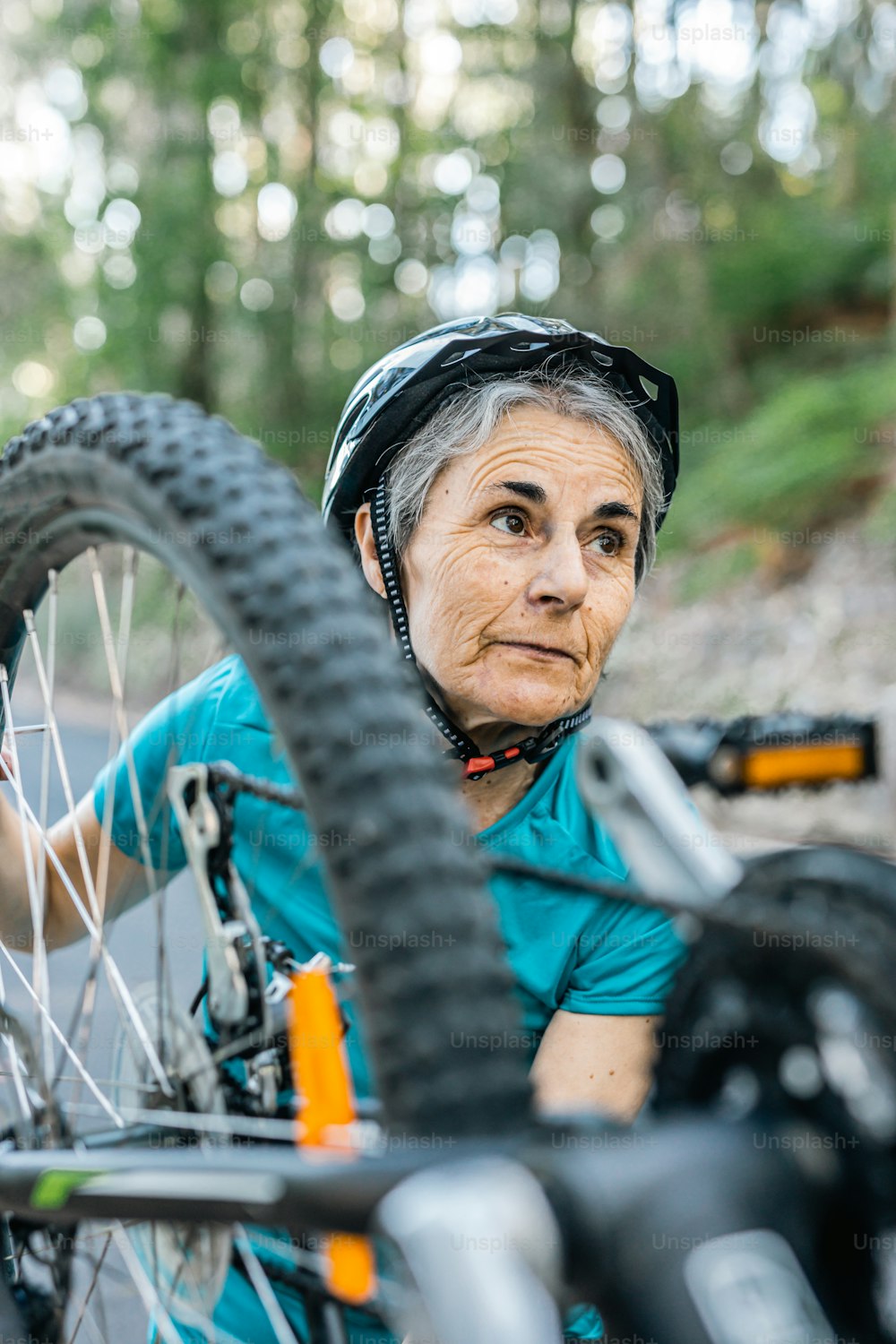a woman with a helmet on is next to a bicycle