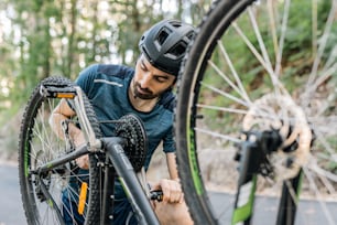 Un uomo che ripara una gomma di bicicletta su una strada