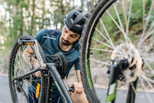 a man fixing a bicycle tire on a road