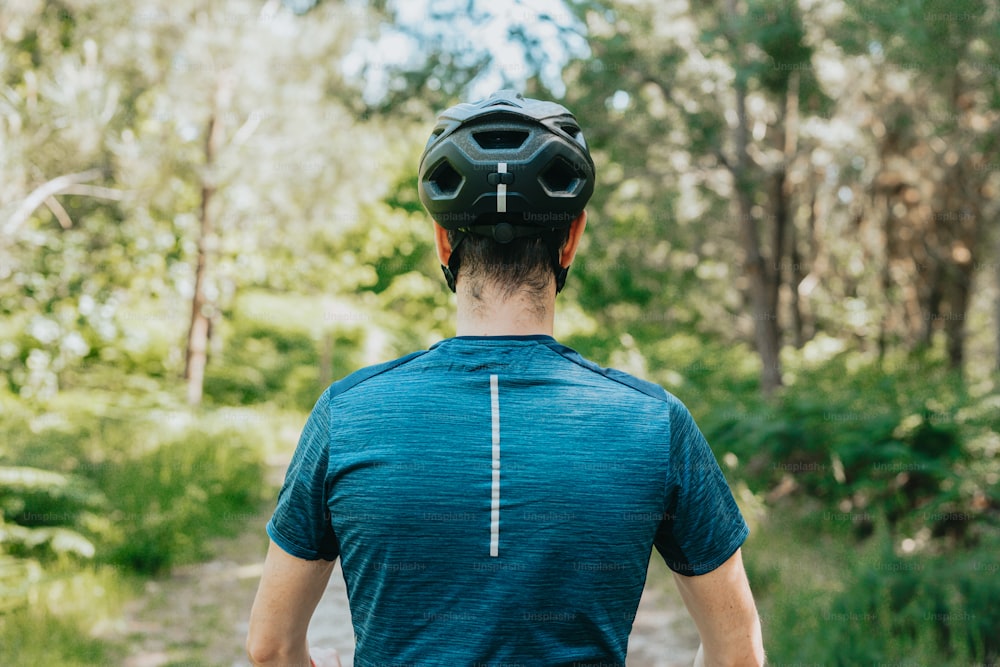 um homem andando de bicicleta por uma floresta