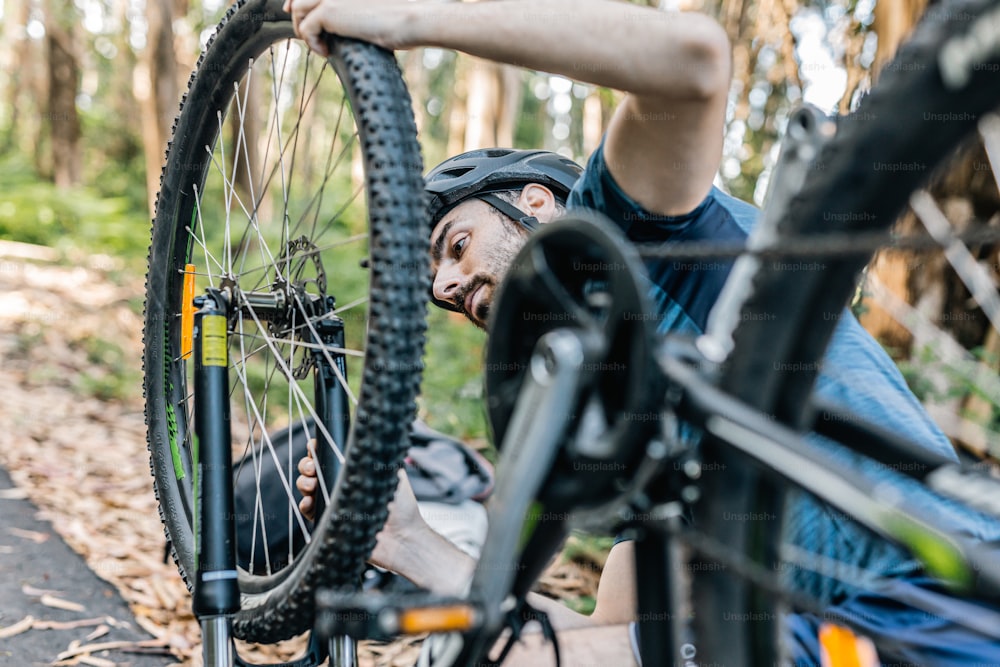 a man with a bike on his back in the woods