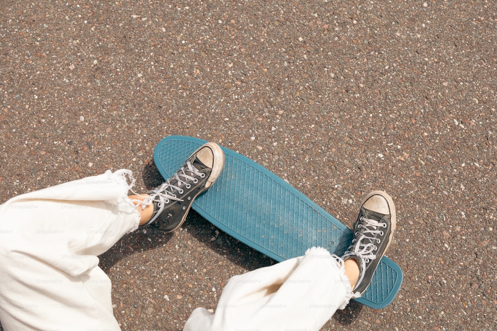 a person standing on top of a blue skateboard