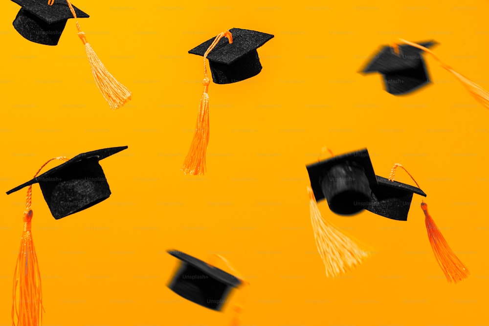 Un grupo de gorras de graduación y borlas volando en el aire