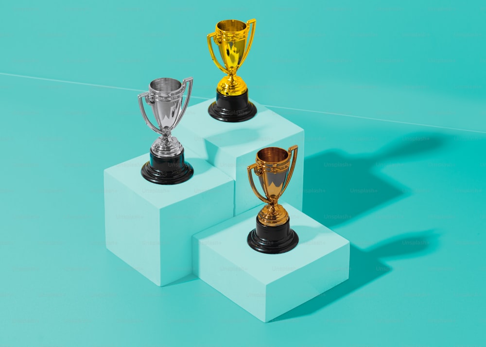 três troféus sentados um em cima do outro