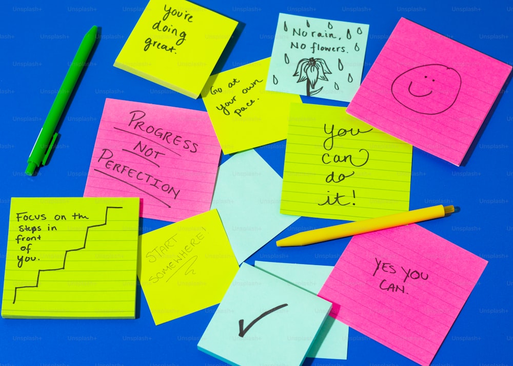 a pile of post it notes sitting on top of a blue table