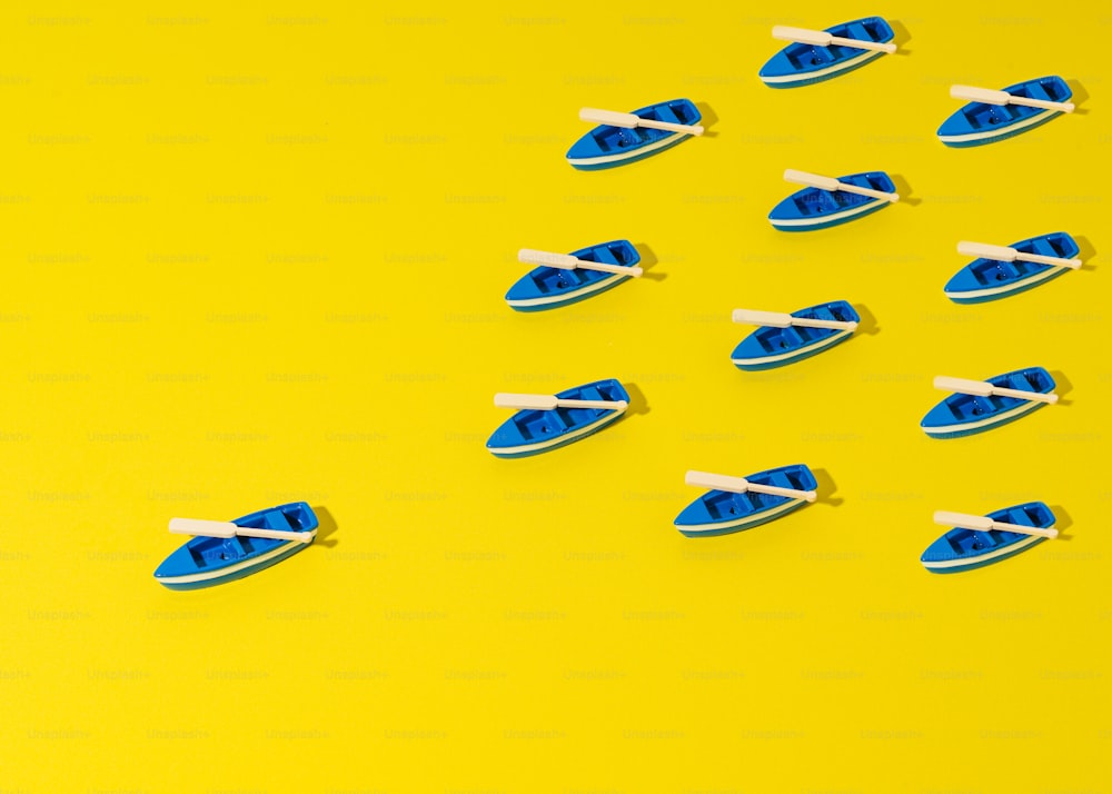 um grupo de barcos de brinquedo azul e branco em um fundo amarelo
