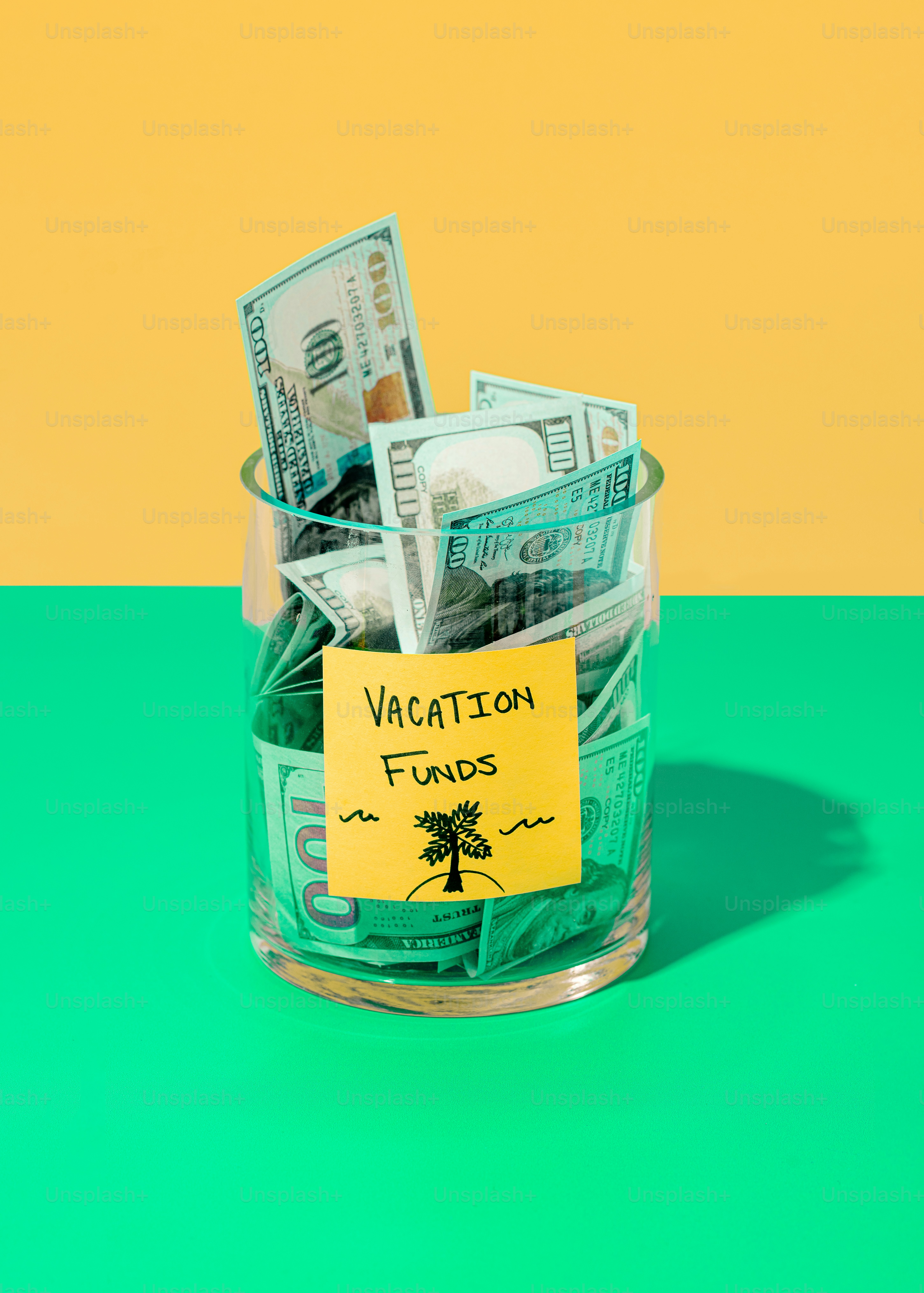 a glass jar filled with money sitting on top of a green table