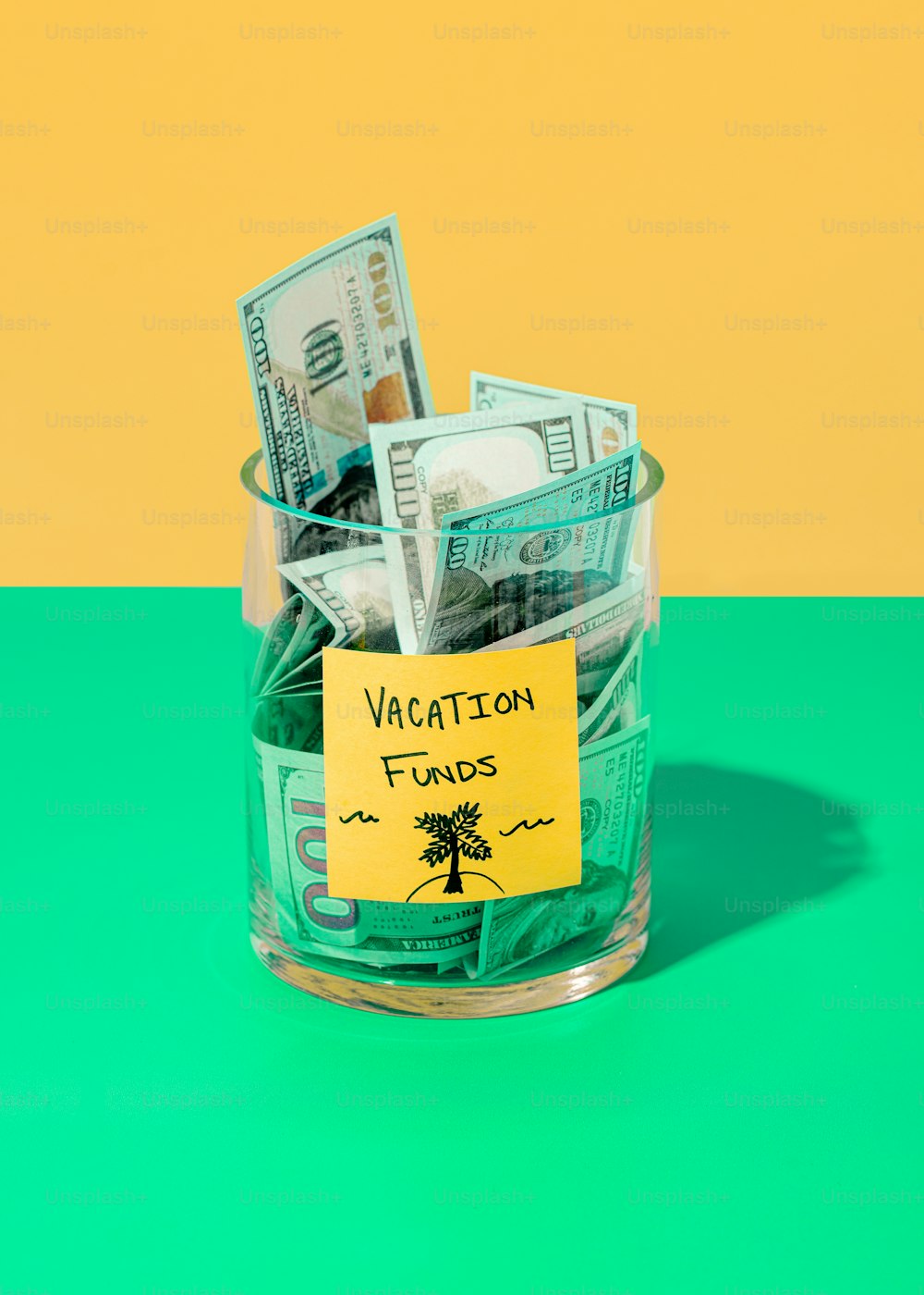 a glass jar filled with money sitting on top of a green table