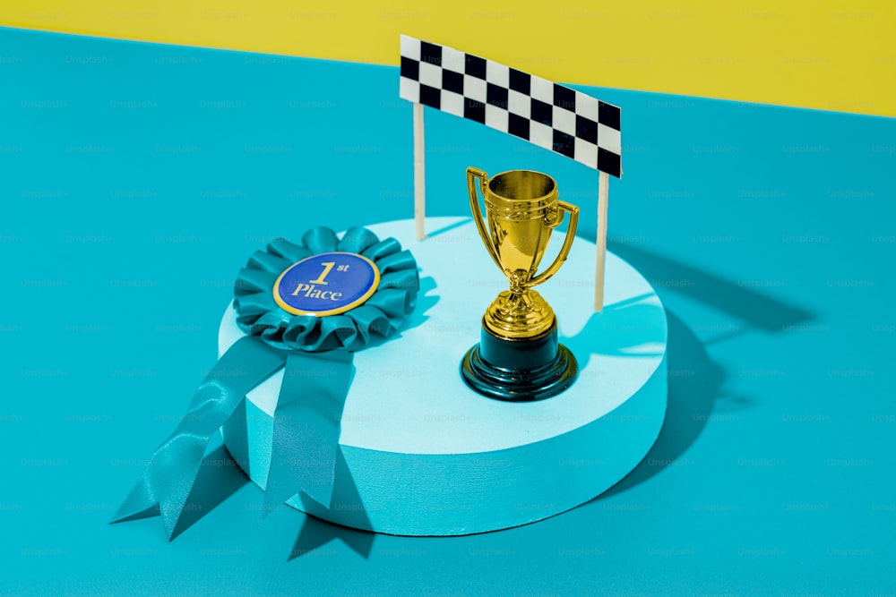 um troféu sentado em cima de uma mesa ao lado de uma fita azul