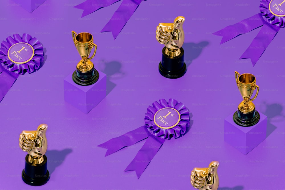 a group of trophies sitting on top of a purple surface