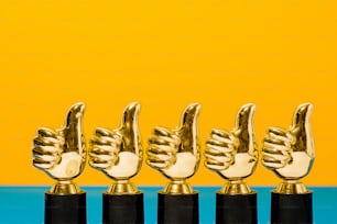 a row of golden and black trophies on a blue and yellow background
