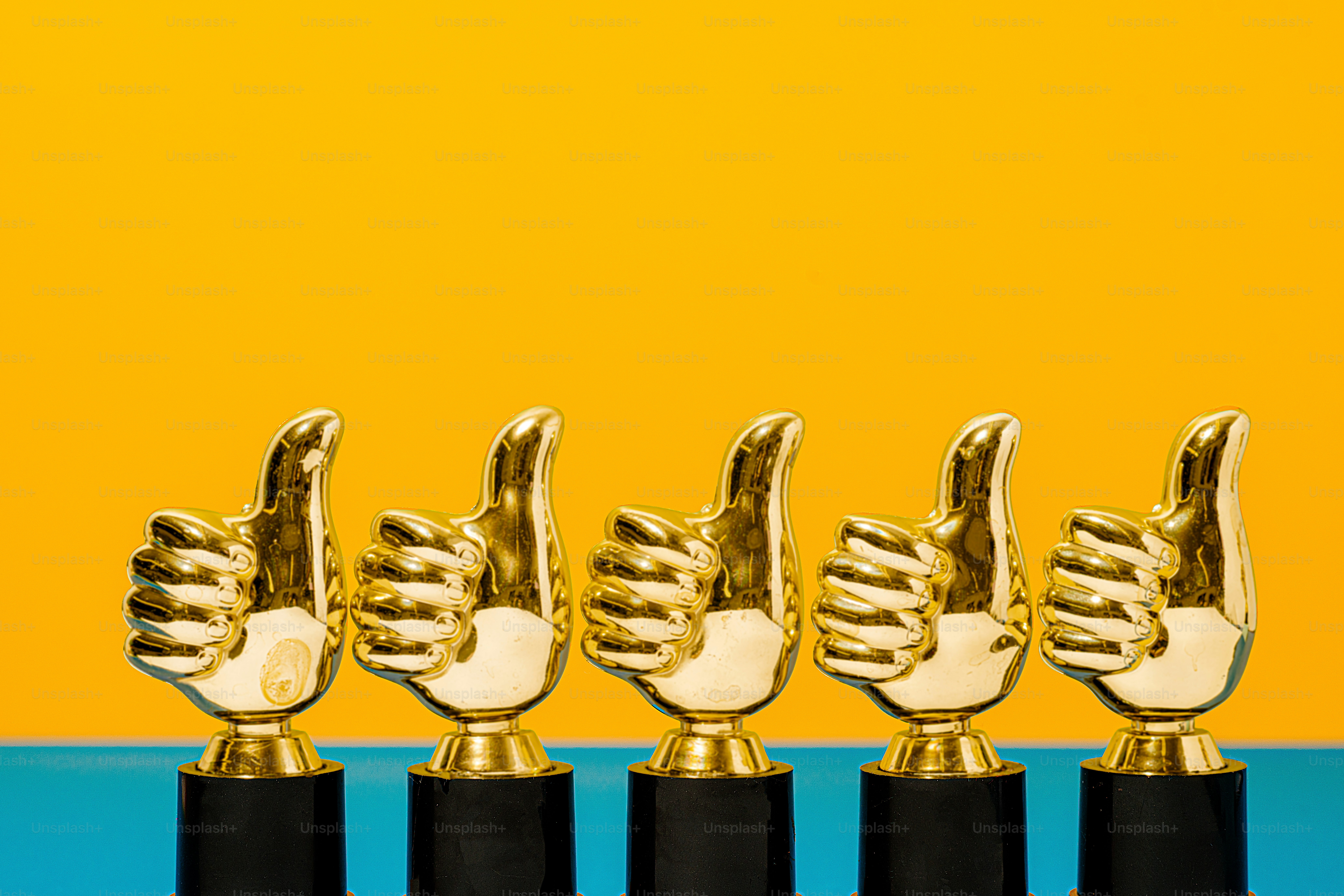 a row of golden and black trophies on a blue and yellow background
