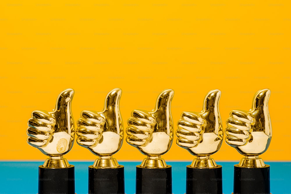 Una fila di trofei dorati e neri su sfondo blu e giallo