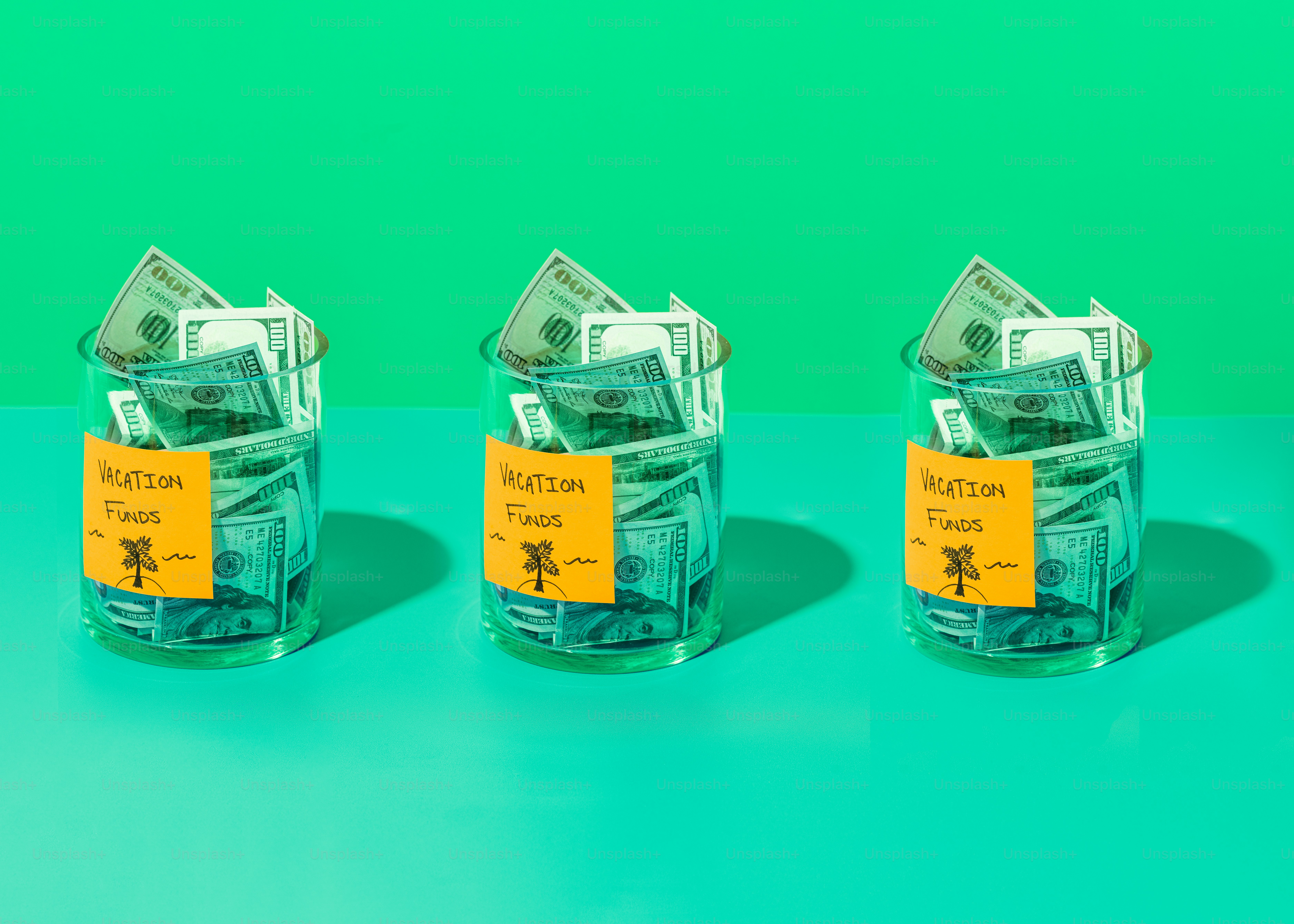 three glass jars with money in them on a table