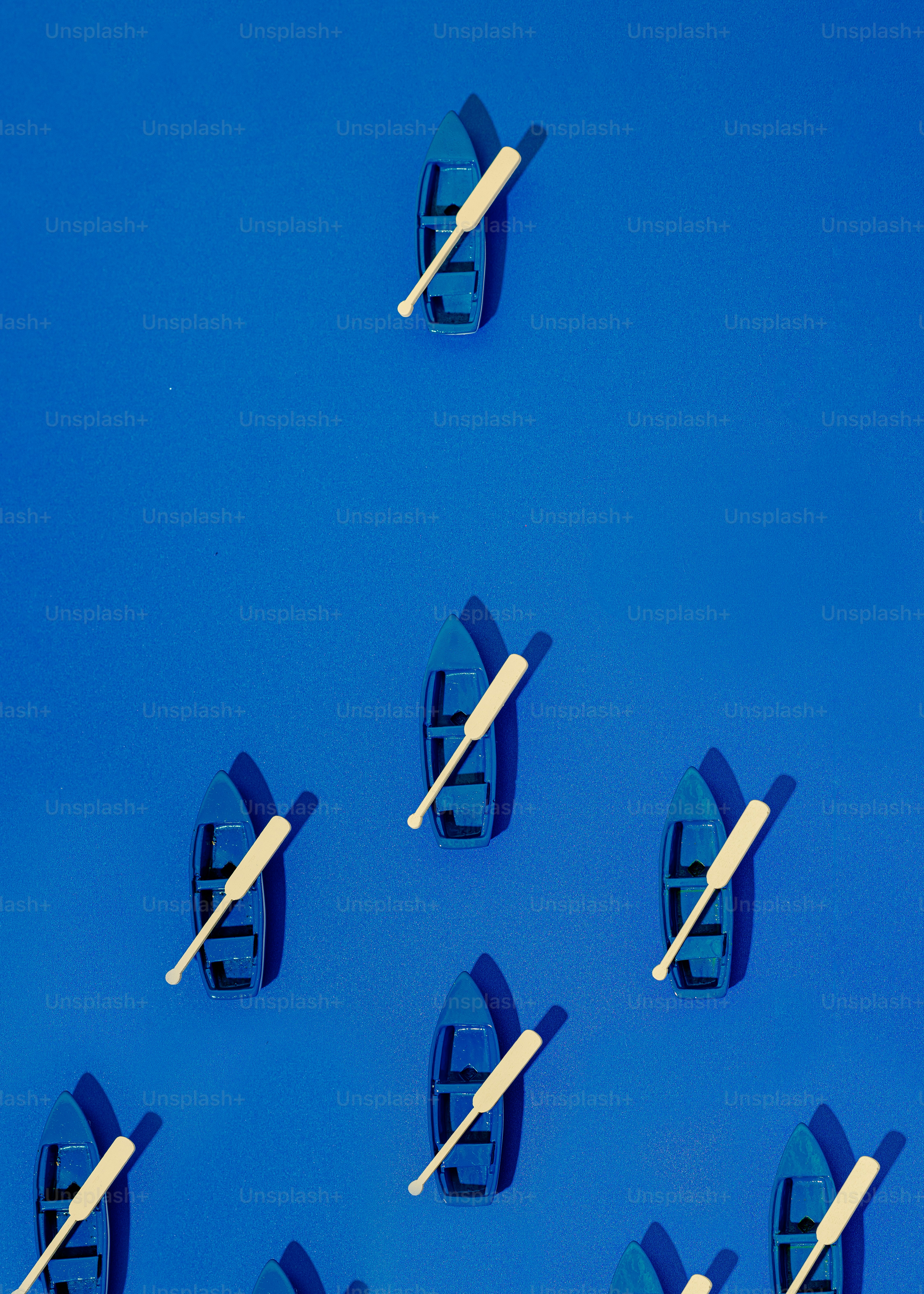 a group of small boats floating on top of a blue surface