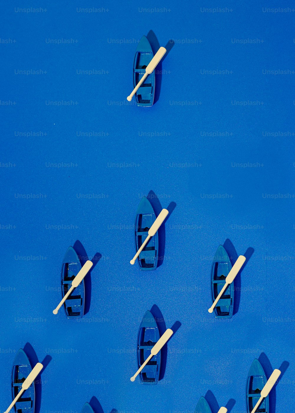um grupo de pequenos barcos flutuando em cima de uma superfície azul