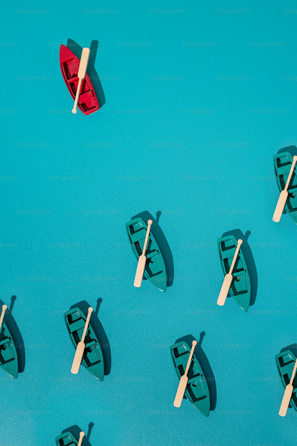 um grupo de pequenos barcos flutuando em cima de uma superfície azul