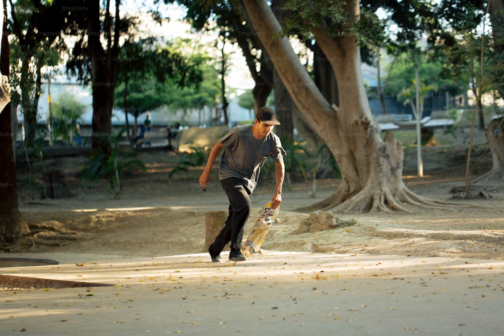 a man holding a skateboard in a park