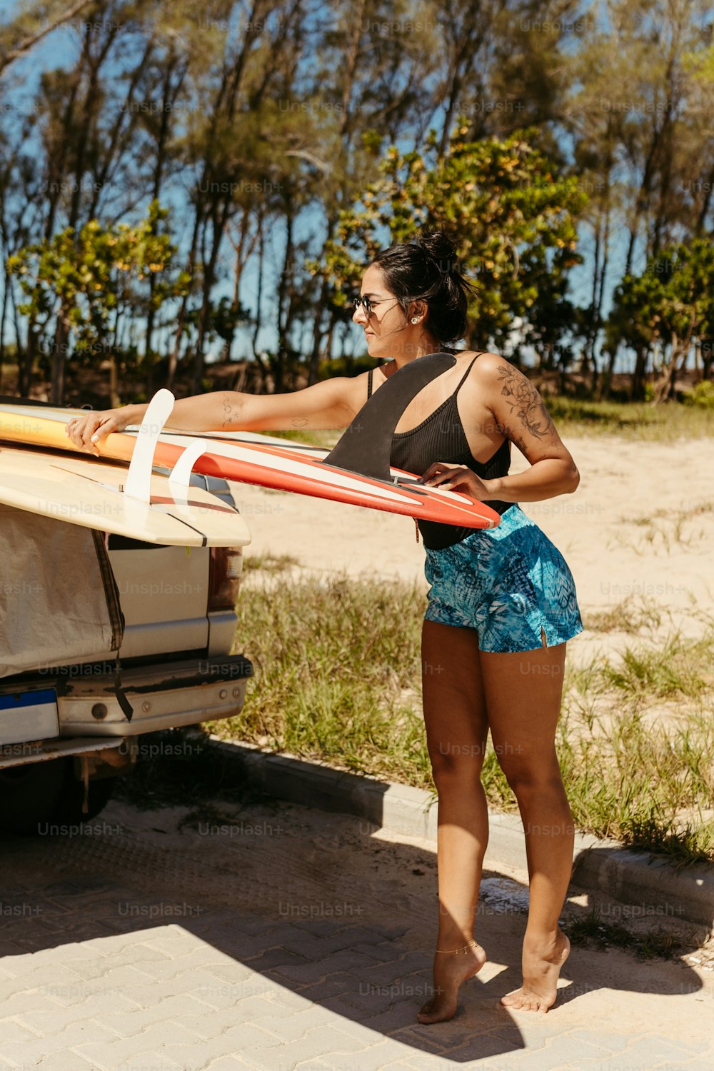 a woman holding a surfboard next to a truck