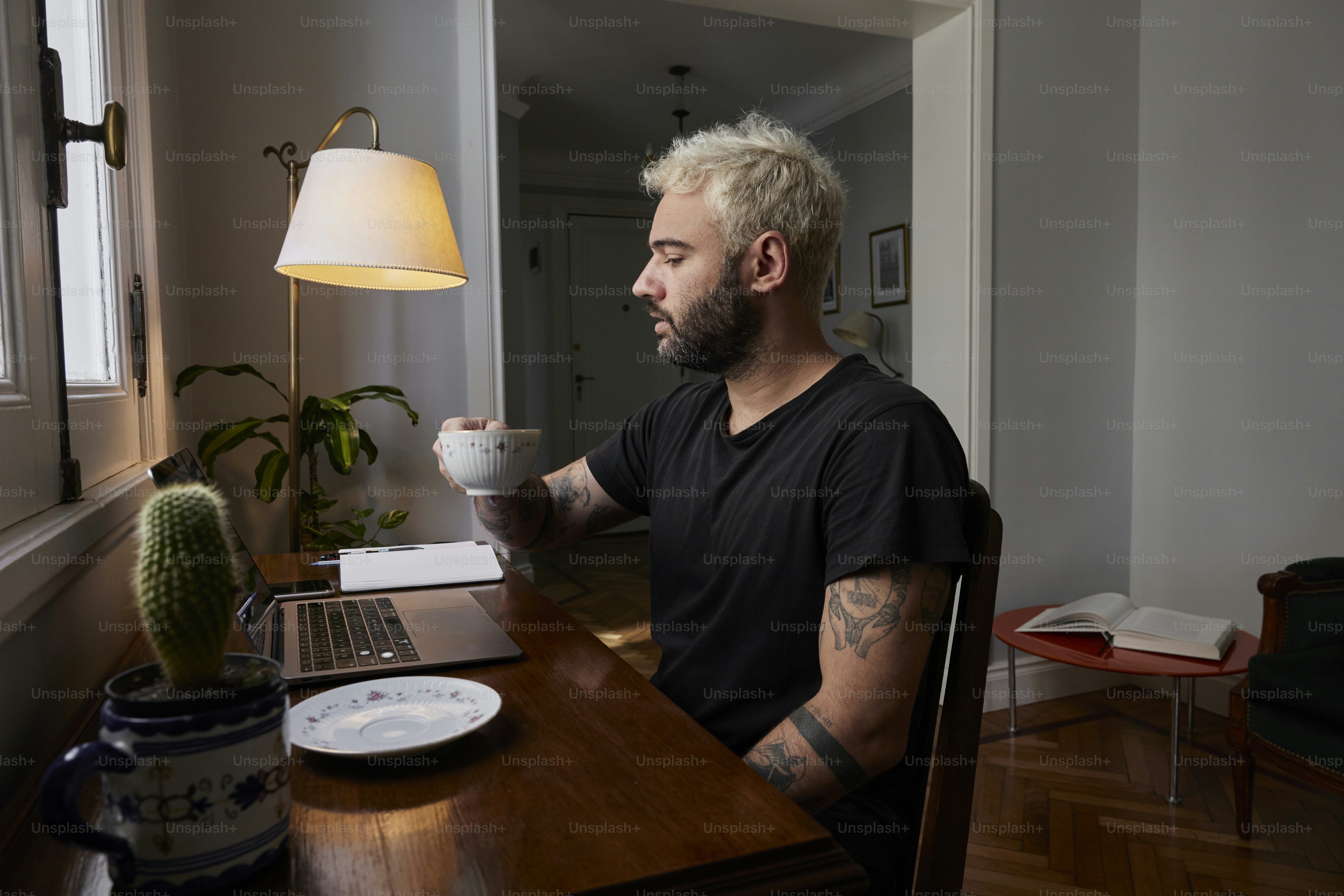 ノートパソコンの前の机に座る男性