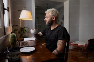 a man sitting at a desk in front of a laptop computer